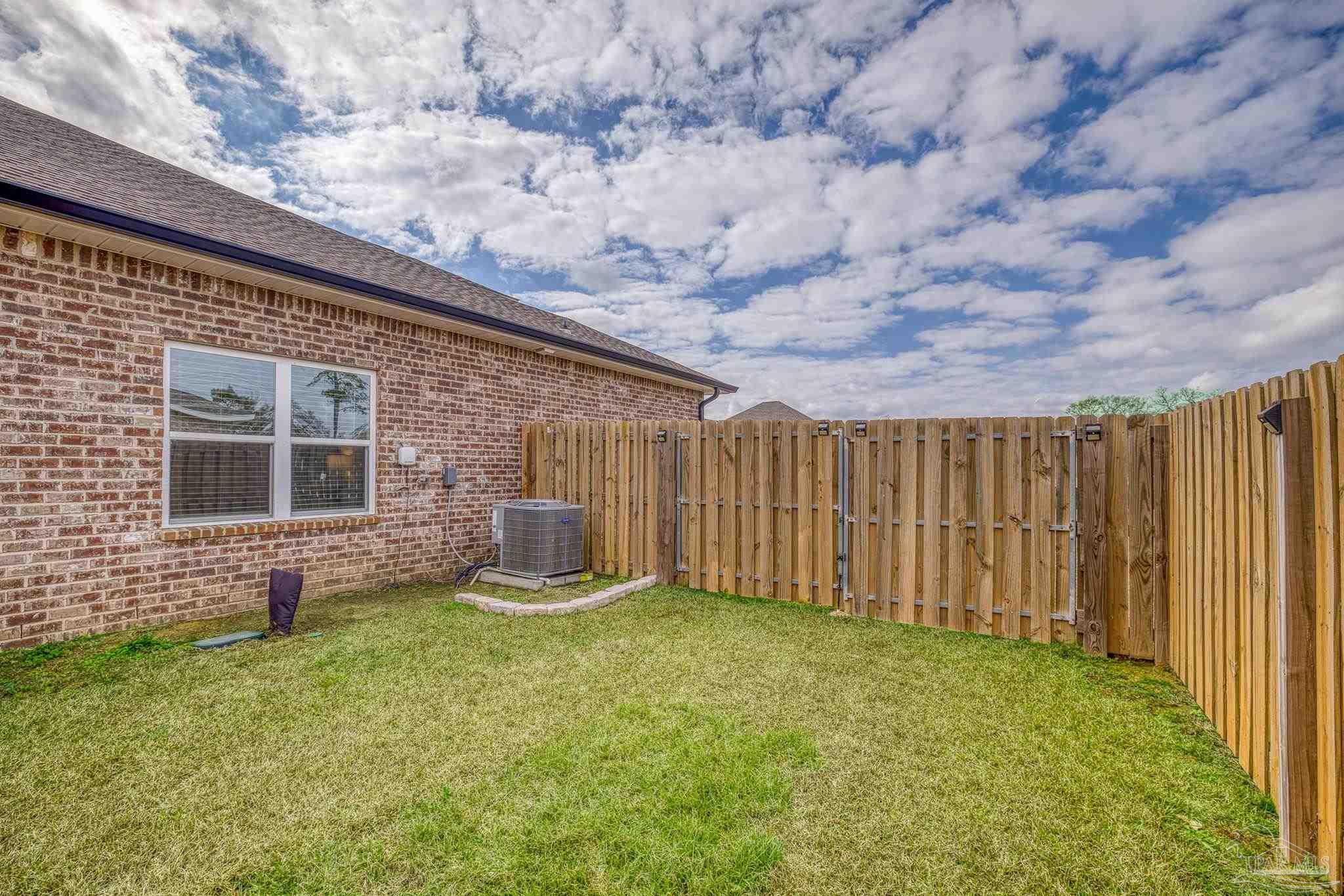 6266 Dry Creek Road Molino, FL 32577 - Photo 50 of 68 a backyard of a house with a garden and outdoor seating