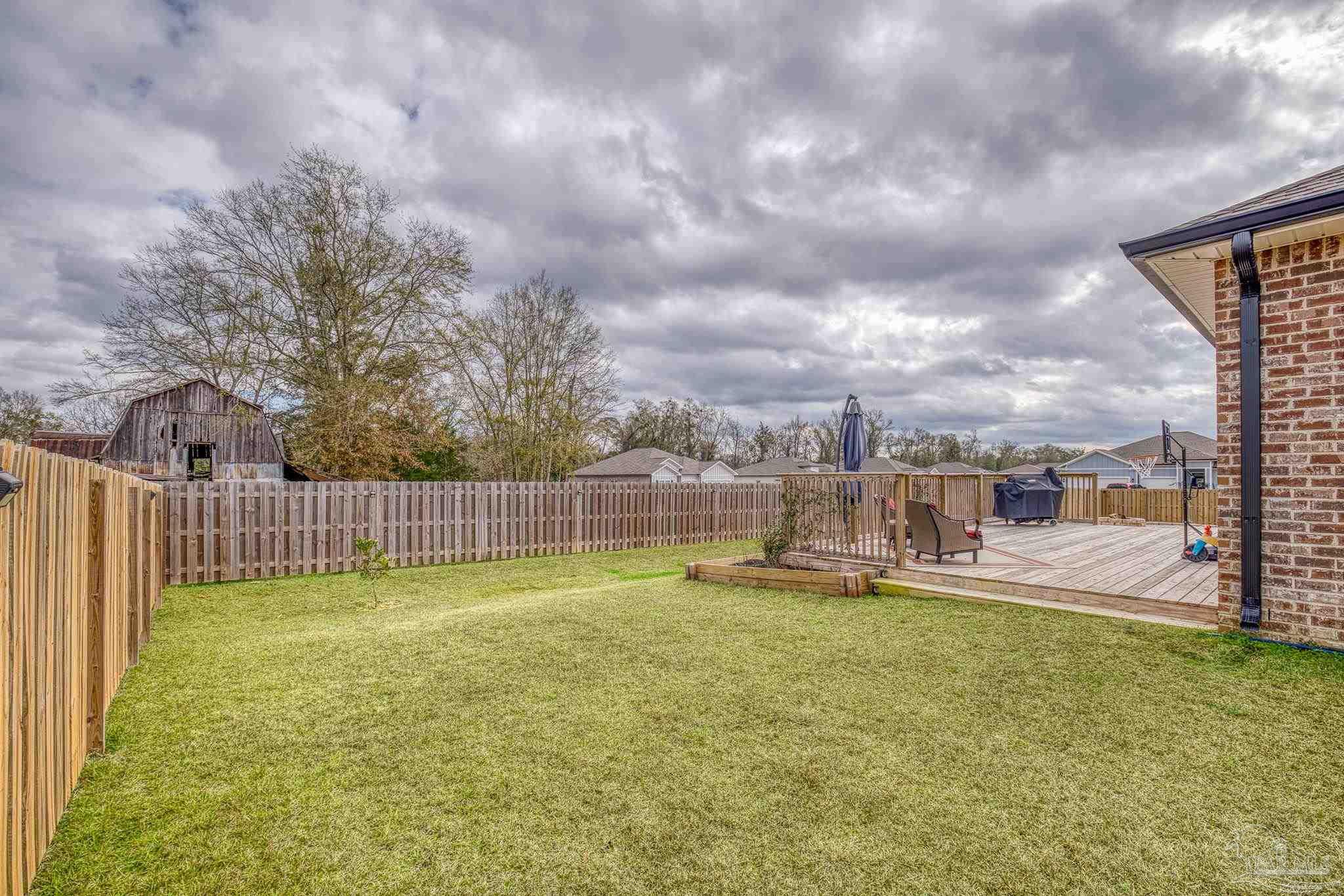 6266 Dry Creek Road Molino, FL 32577 - Photo 51 of 68 a view of a swimming pool with a yard and a trees in the background