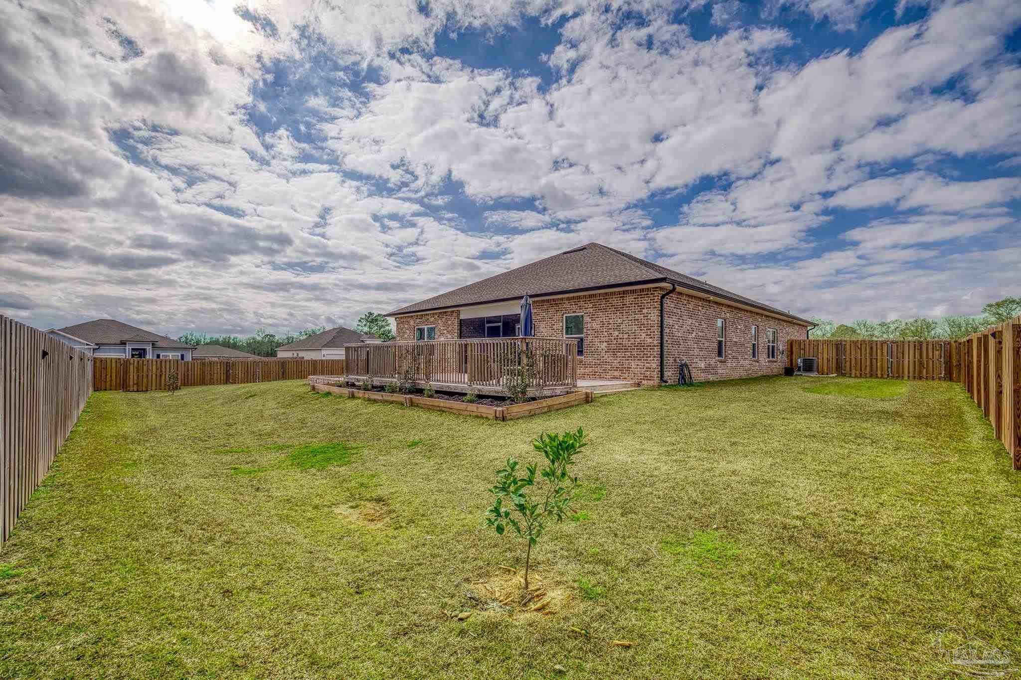 6266 Dry Creek Road Molino, FL 32577 - Photo 53 of 68 a backyard of a house with large trees and wooden fence