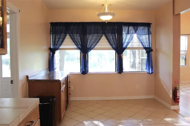 a kitchen with a window a dining table and chairs