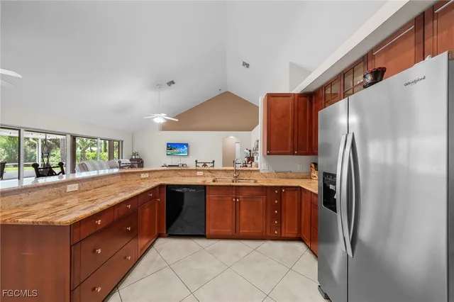 a kitchen with stainless steel appliances granite countertop a sink and a refrigerator