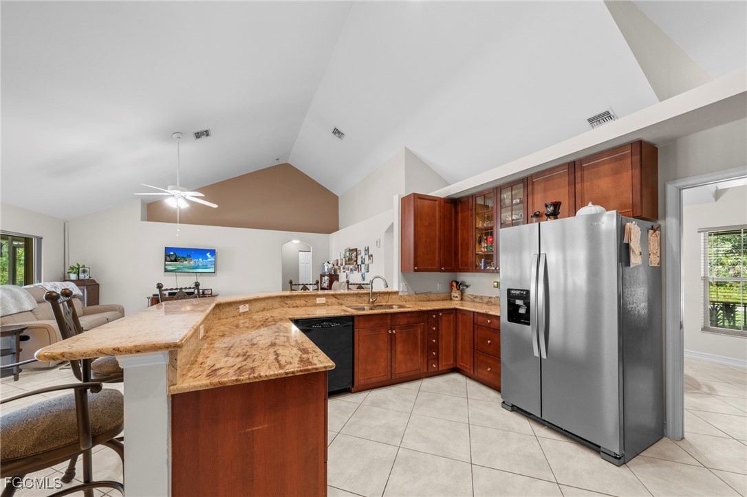 90 24th Avenue Northeast Naples, FL 34120 - Photo 13 of 44 a kitchen with stainless steel appliances granite countertop a refrigerator and a stove top oven