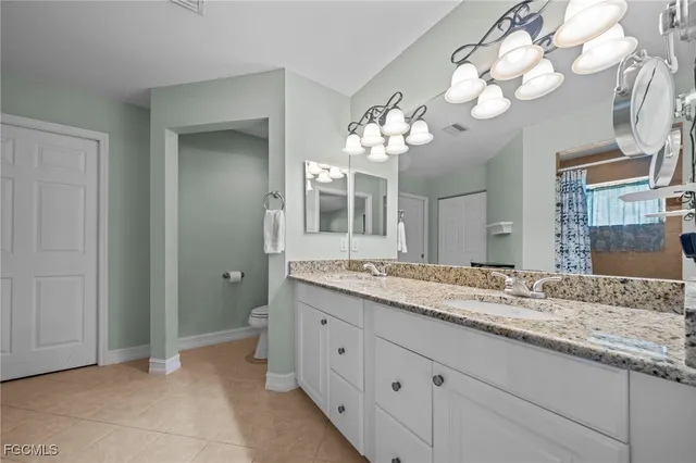 a bathroom with a granite countertop double vanity sink and a mirror
