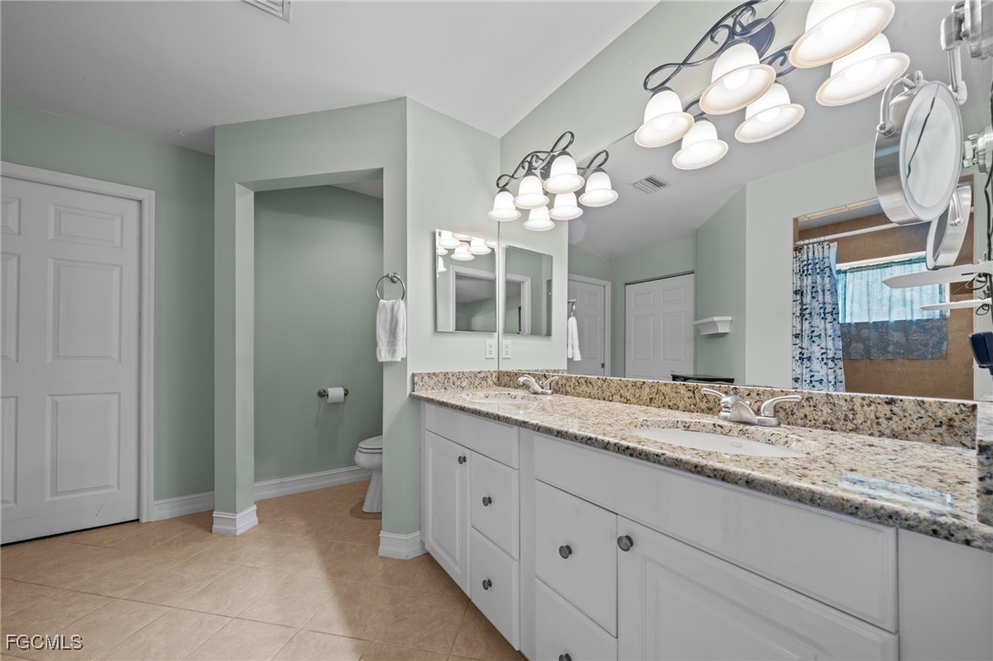 90 24th Avenue Northeast Naples, FL 34120 - Photo 17 of 44 a bathroom with a granite countertop double vanity sink and a mirror