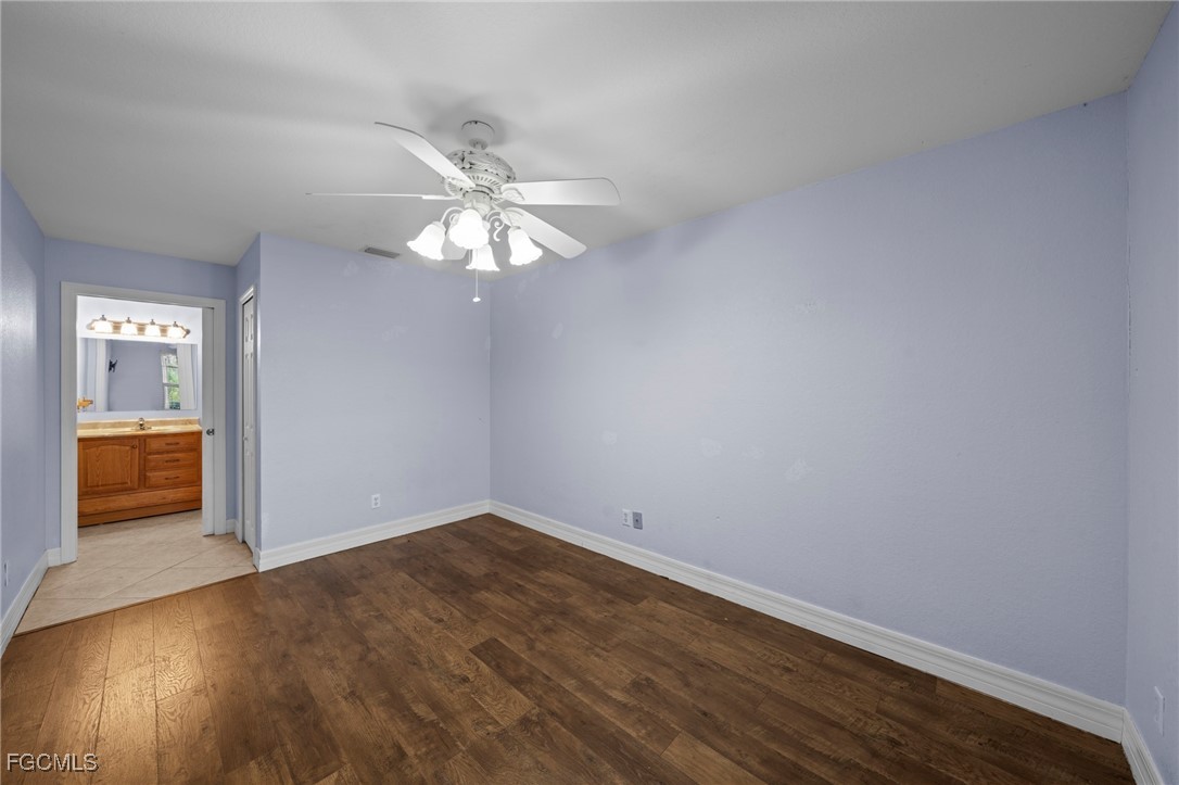 90 24th Avenue Northeast Naples, FL 34120 - Photo 20 of 50 an empty room with wooden floor and chandelier
