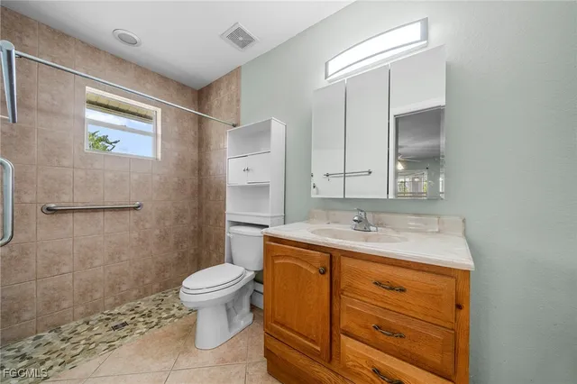 a bathroom with a granite countertop sink a toilet and a mirror