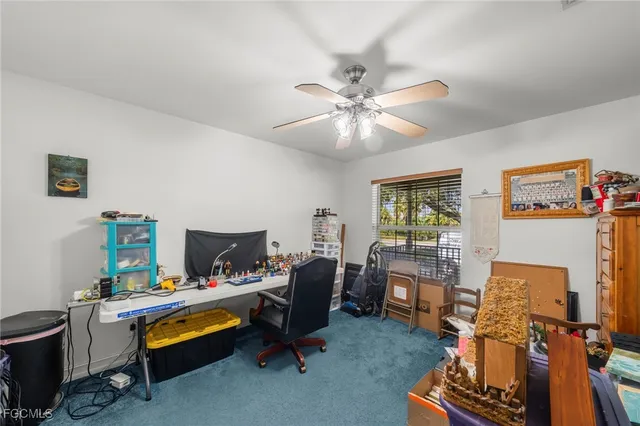 a view of a workspace with furniture and a window