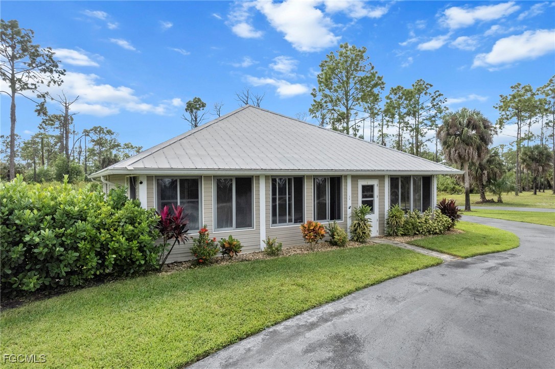 90 24th Avenue Northeast Naples, FL 34120 - Photo 26 of 44 a front view of a house with garden and trees