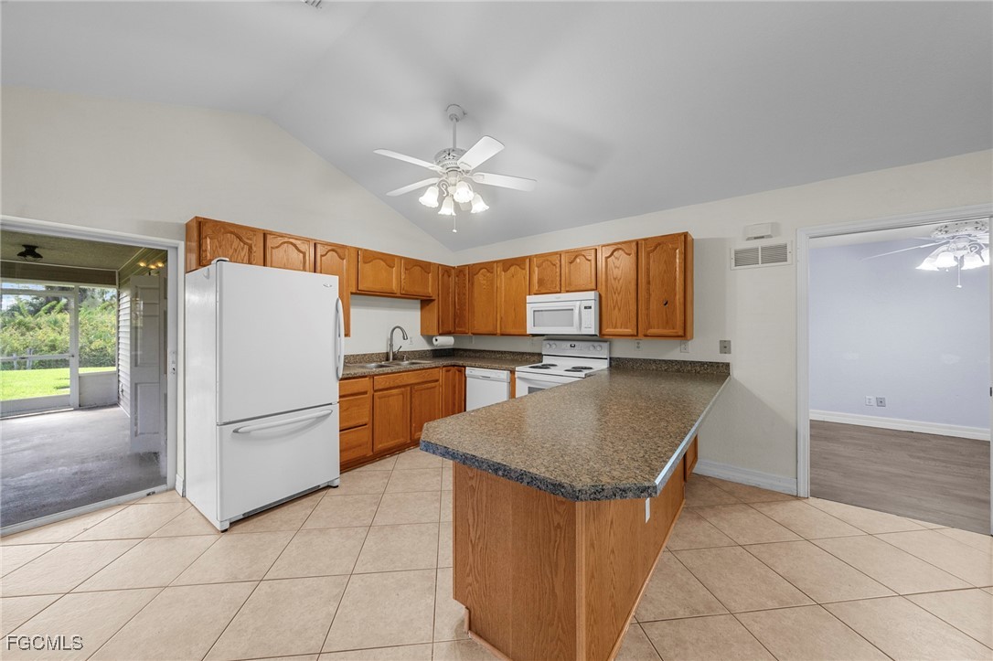 90 24th Avenue Northeast Naples, FL 34120 - Photo 29 of 50 a kitchen with refrigerator cabinets and wooden floor