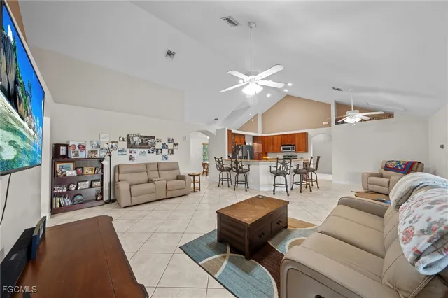 a living room with furniture kitchen view and a chandelier
