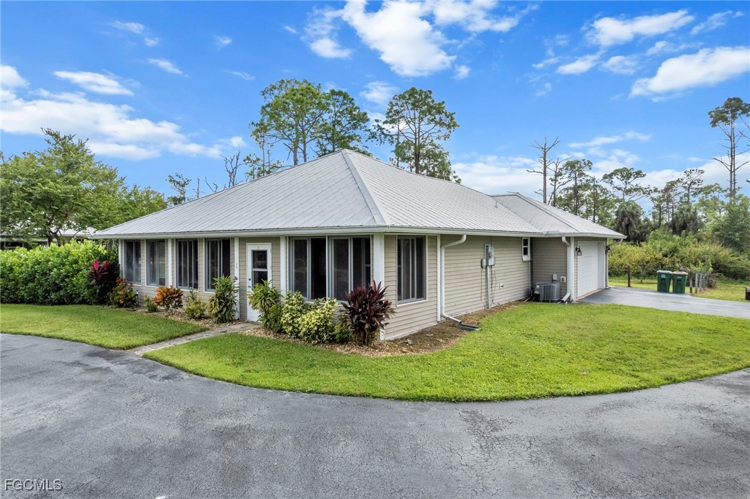 90 24th Avenue Northeast Naples, FL 34120 - Photo 32 of 50 a front view of a house with a garden and plants