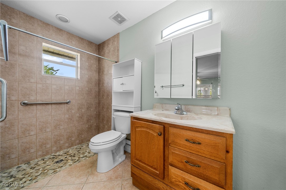 90 24th Avenue Northeast Naples, FL 34120 - Photo 34 of 44 a bathroom with a granite countertop sink a toilet and a mirror