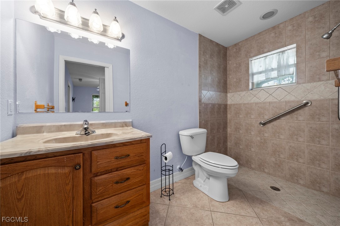 90 24th Avenue Northeast Naples, FL 34120 - Photo 37 of 50 a bathroom with a granite countertop toilet a sink and a mirror