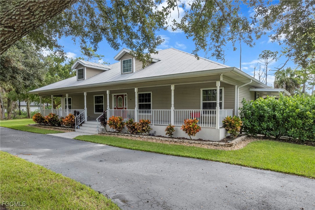 90 24th Avenue Northeast Naples, FL 34120 - Photo 4 of 44 a front view of a house with garden and porch