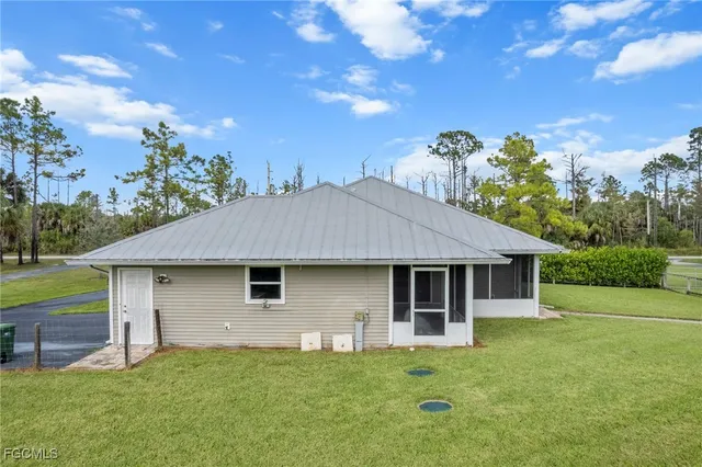 a small white house with a white roof and wooden fence