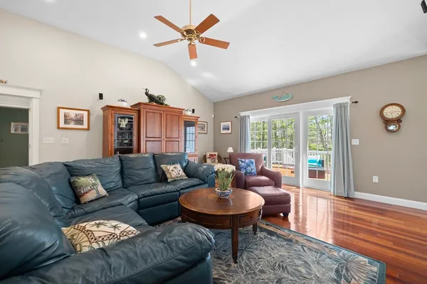 a living room with furniture a rug potted plant and a large window