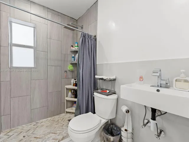 a white toilet sitting next to a bathroom sink and vanity