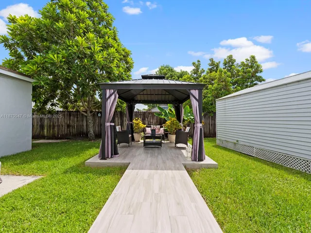 a view of house with backyard swimming pool and sitting area