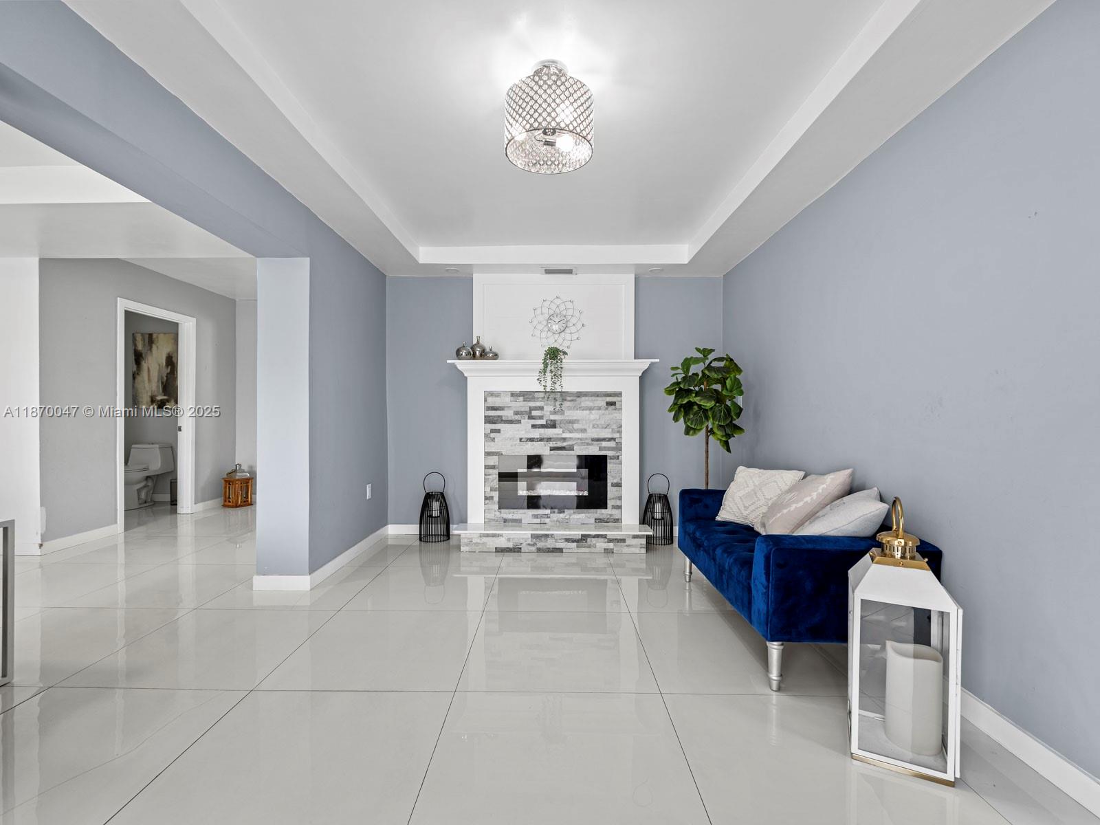 11350 Southwest 46th Street Miami, FL 33165 - Photo 3 of 20 a living room with furniture a fireplace and a chandelier