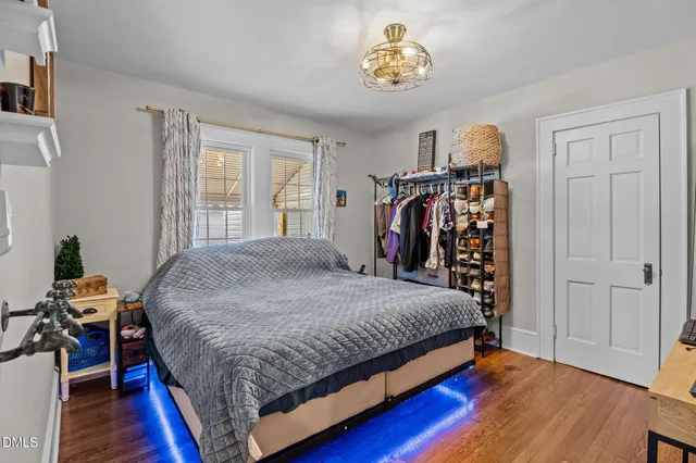 a bedroom with a bed and a flat tv screen on dresser