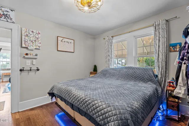 a bedroom with a bed and a lamp with wooden floor
