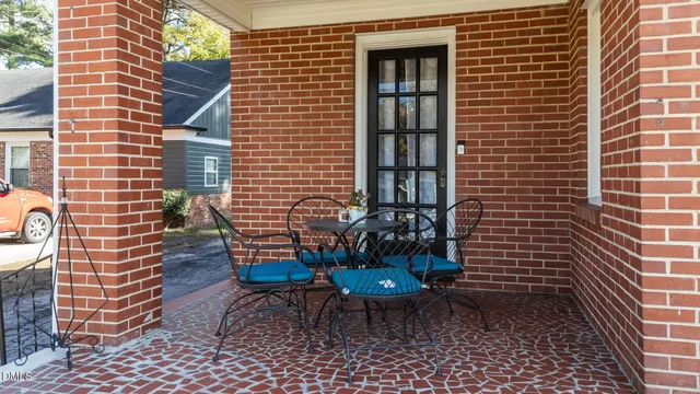 a view of a patio with a table and chairs and potted plants