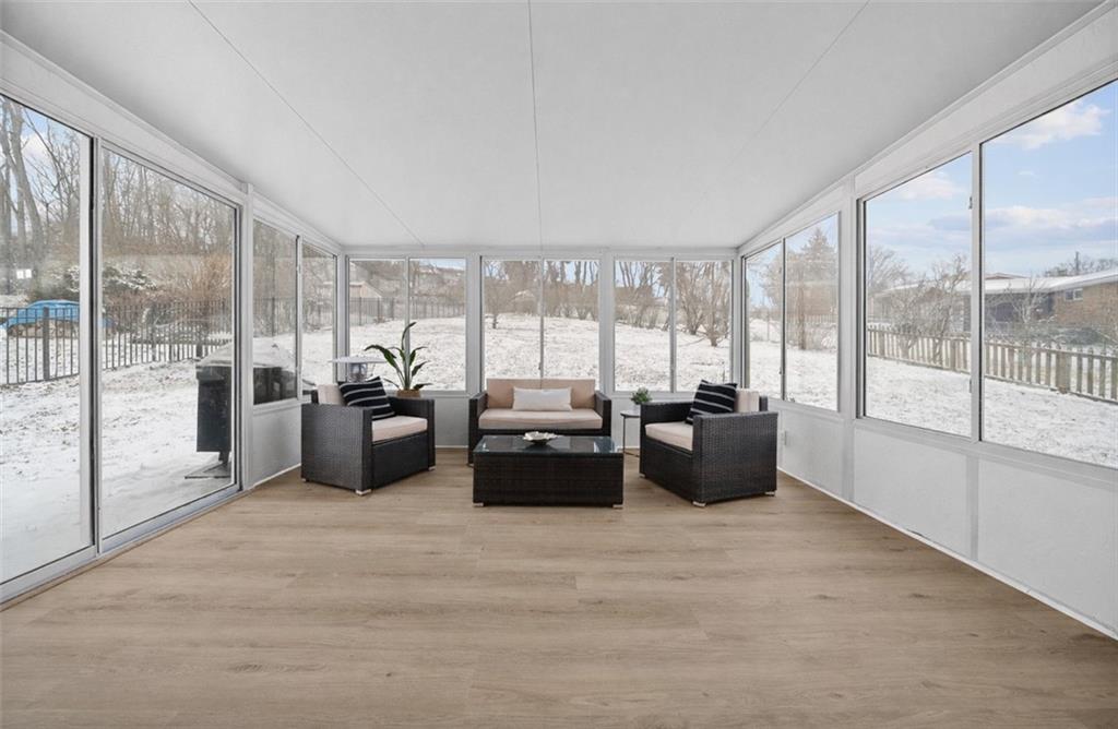 106 Windsor Drive Irwin, PA 15642 - Photo 13 of 30 Three-season room overlooking the fully fenced backyard, creating a peaceful indoor-outdoor connection.
