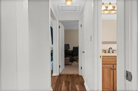 a view of a hallway with wooden floor and a living room