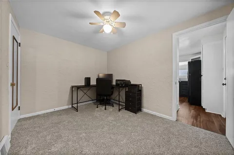 a view of a workspace with furniture and a chandelier fan
