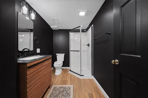 a bathroom with a sink a toilet and shower