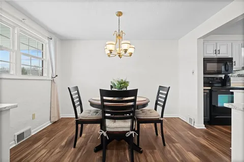 a view of a dining room with furniture wooden floor and a chandelier