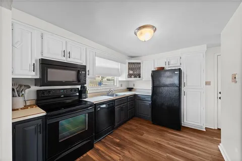 a kitchen with a refrigerator and a stove top oven