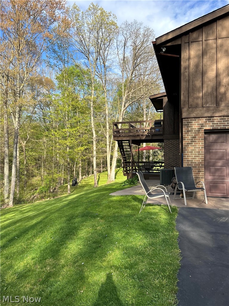 8871 Clinton Road Cambridge, OH 43725 - Photo 5 of 33 View of yard featuring a garage, a deck, and a patio