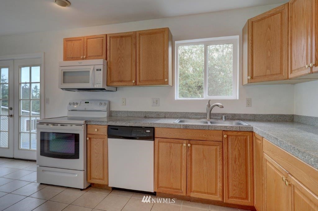 5711 Cady Road Everett, WA 98203 - Photo 4 of 15 a kitchen with granite countertop white cabinets and white appliances
