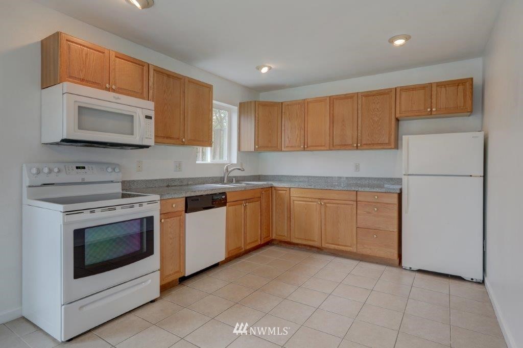 5711 Cady Road Everett, WA 98203 - Photo 5 of 15 a kitchen with white cabinets stainless steel appliances and a sink