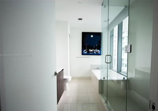 a view of a hallway with wooden floor and a living room