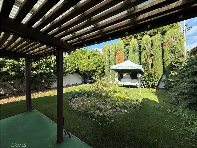 a backyard of a house with a garden and outdoor seating