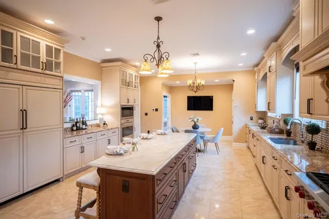 a large kitchen with kitchen island a sink a counter space and stainless steel appliances