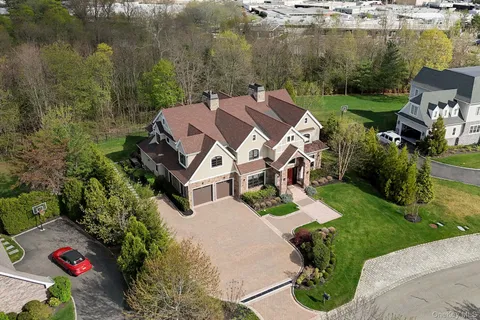 an aerial view of a house with a garden and lake view