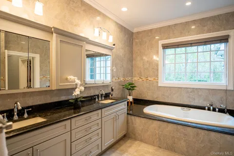 a spacious bathroom with a granite countertop tub sink and mirror