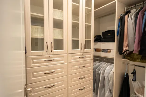 a view of walk in closet with clothes and shoes
