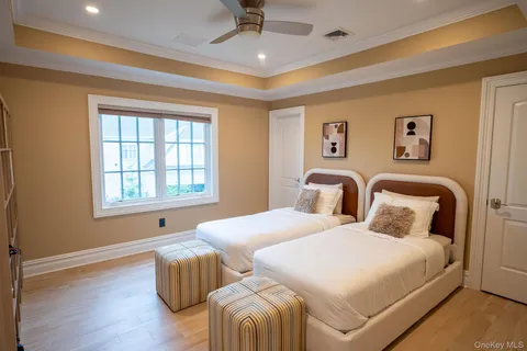 a bedroom with two beds and wooden floor
