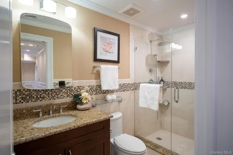 a bathroom with a granite countertop sink toilet and shower