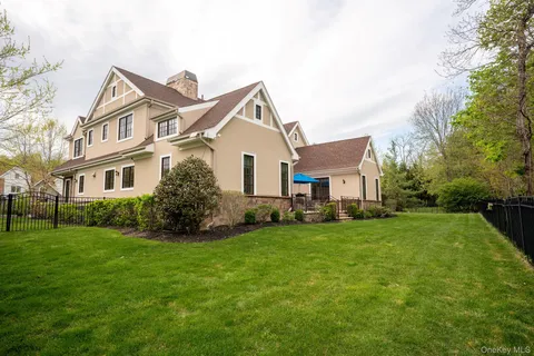 a view of a house with a big yard and large trees