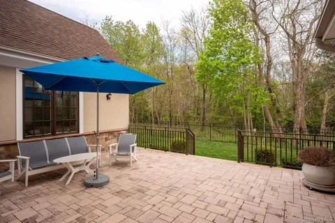 a view of a patio with chairs and umbrellas