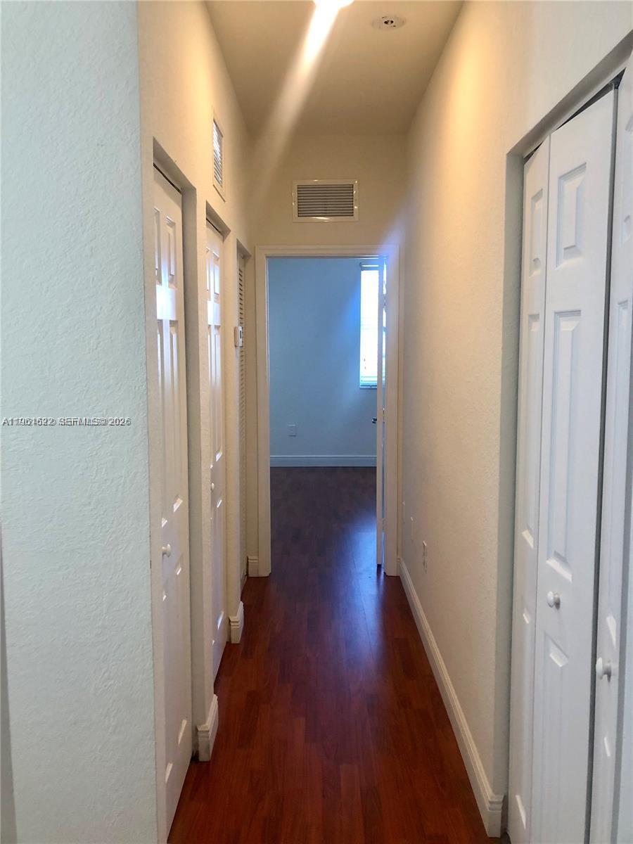 9041 Southwest 227th Street, Unit 5 Cutler Bay, FL 33190 - Photo 13 of 27 a view of a hallway with wooden floor