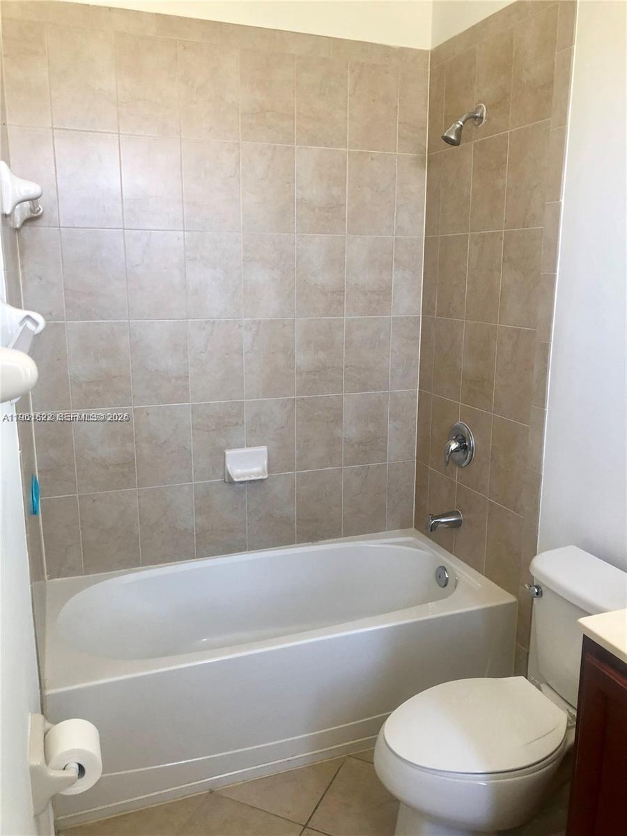 9041 Southwest 227th Street, Unit 5 Cutler Bay, FL 33190 - Photo 15 of 27 a white toilet and tub sitting next to a bathroom sink