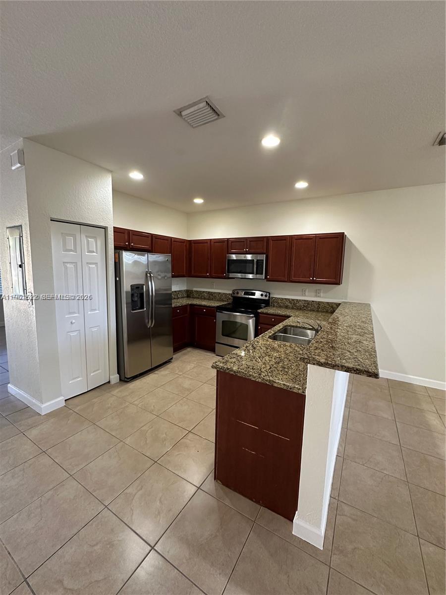 9041 Southwest 227th Street, Unit 5 Cutler Bay, FL 33190 - Photo 2 of 27 a kitchen with stainless steel appliances granite countertop a refrigerator and a stove