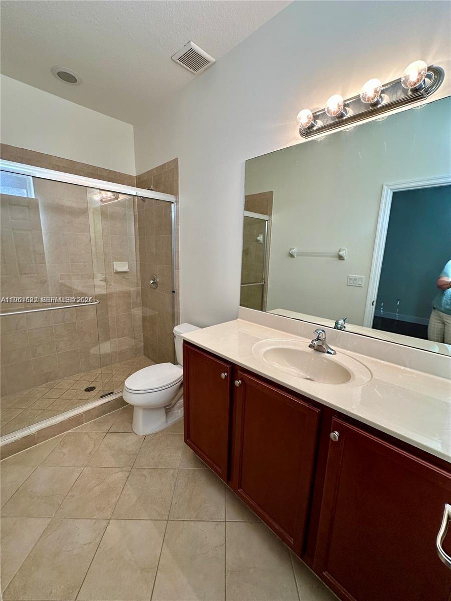 9041 Southwest 227th Street, Unit 5 Cutler Bay, FL 33190 - Photo 21 of 27 a bathroom with a double vanity sink toilet and shower