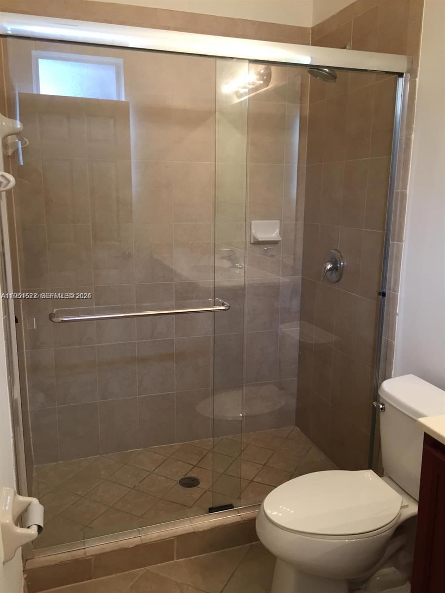 9041 Southwest 227th Street, Unit 5 Cutler Bay, FL 33190 - Photo 23 of 27 a bathroom with a shower and a toilet